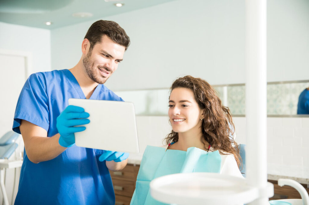 Un dentista muestra a su paciente el resultado de la cita