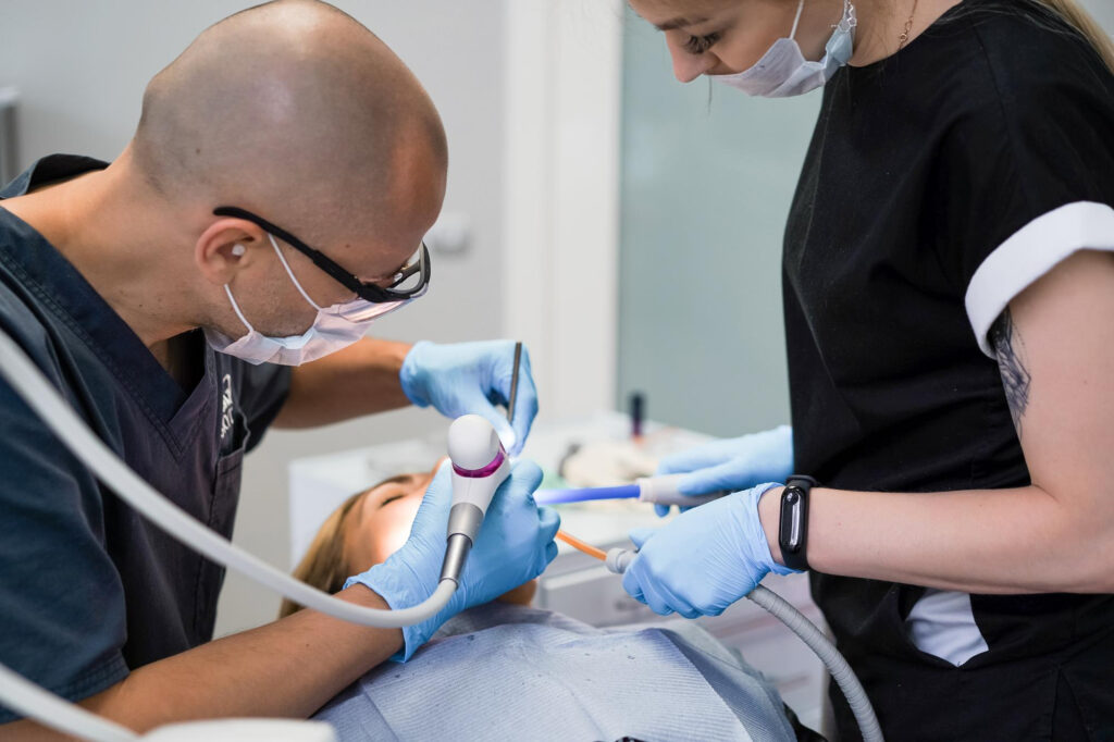 Un dentista y su asistente realizan un tratamiento dental