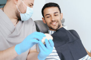Un dentista muestra un molde dental a su paciente